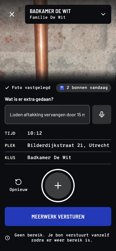Het vastlegscherm van Meerstaat op een telefoon, met de post van een loodgieter: de foto is gemaakt (Een opengebroken wand met roze baksteen erachter, twee koperen leidingen met een T-stuk, en gruis op de vloer ervoor), boven het scherm staat de klus Badkamer De Wit, het veld wat is er extra gedaan is ingevuld met "Loden aftakking vervangen door 15 mm koper, twee knelkoppelingen, afgeperst. Uur extra.", en tijd en plek staan er automatisch onder, met de knop meerwerk versturen. Onderaan staat de melding geen bereik, je bon verstuurt vanzelf zodra er weer bereik is.